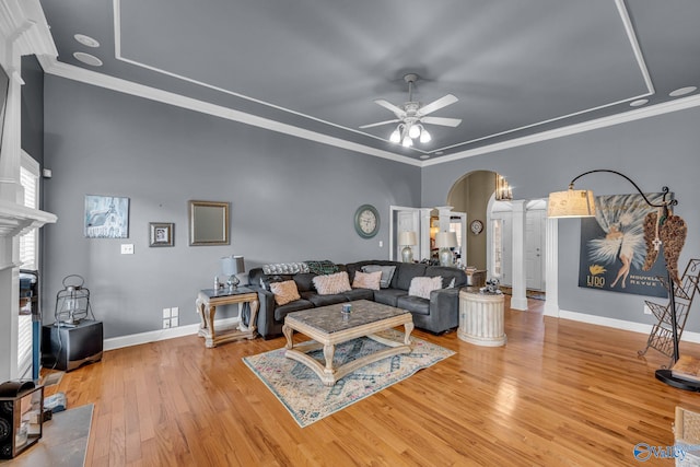 living room featuring light hardwood / wood-style flooring, ceiling fan, and crown molding