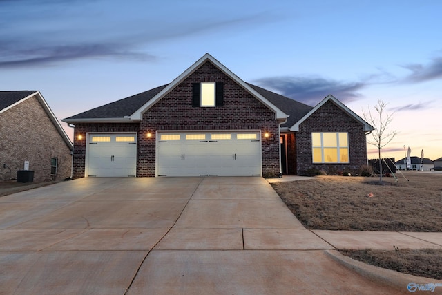 view of front of house featuring a garage, concrete driveway, roof with shingles, central air condition unit, and brick siding