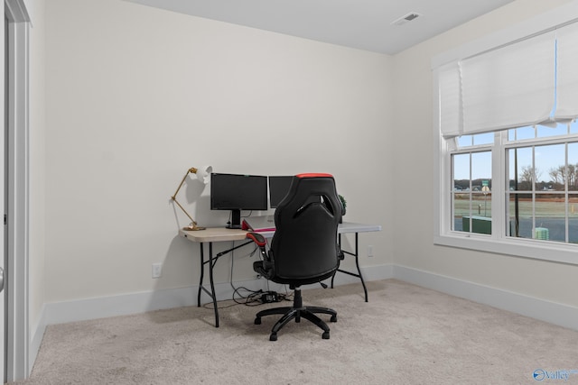 carpeted office space featuring visible vents and baseboards