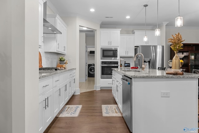 kitchen featuring appliances with stainless steel finishes, washer / dryer, a sink, and ornamental molding