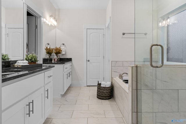 full bathroom featuring marble finish floor, two vanities, a sink, a shower stall, and a bath