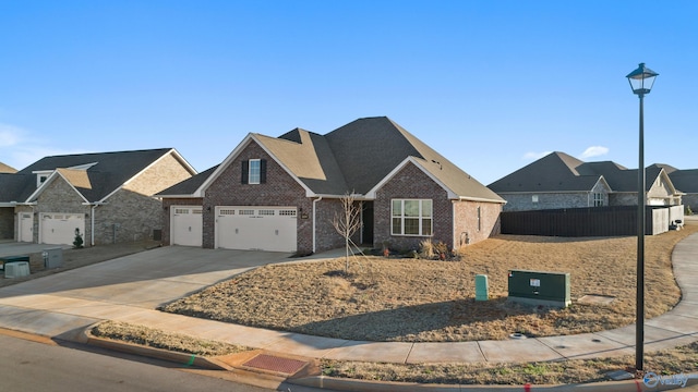 view of front facade with concrete driveway, brick siding, an attached garage, and fence