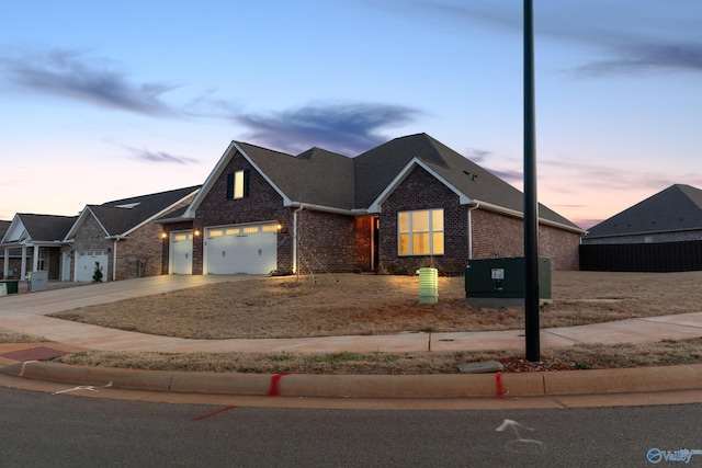 view of front of property featuring an attached garage, concrete driveway, and brick siding