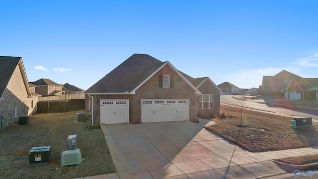 view of front of home with central AC, fence, concrete driveway, and brick siding