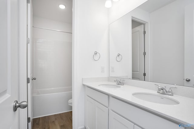 full bathroom featuring vanity, hardwood / wood-style flooring,  shower combination, and toilet