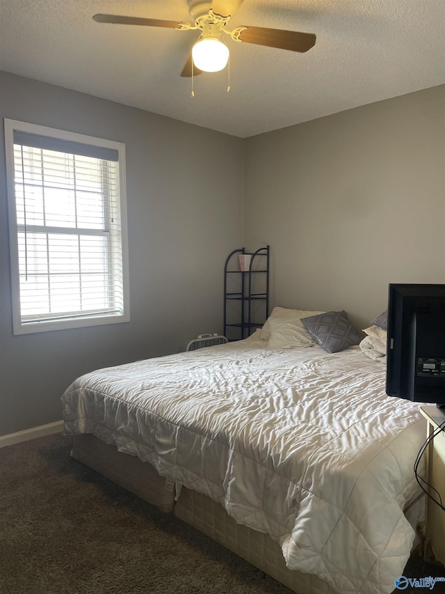 carpeted bedroom with a textured ceiling, ceiling fan, and baseboards