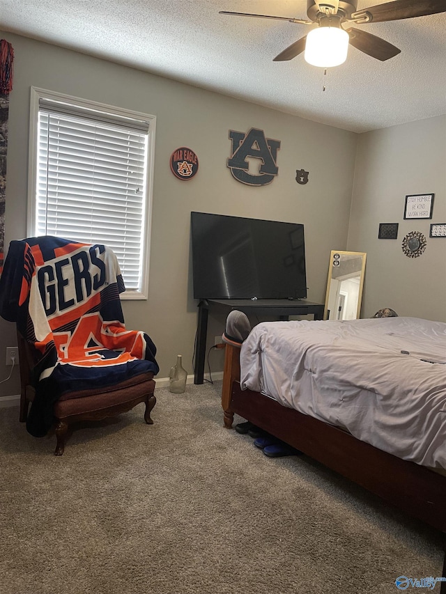 carpeted bedroom with a ceiling fan, a textured ceiling, and baseboards