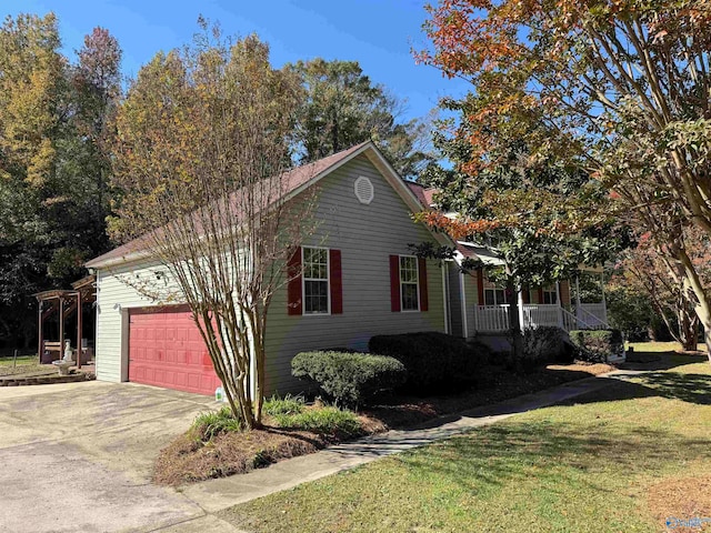 view of front of property featuring a porch, a front yard, and a garage