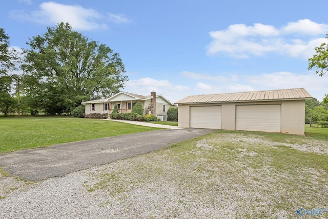 431 County Road 449, Town Creek, AL 35672 - view of front of house featuring a garage, an outdoor structure, a front lawn, metal roof, and concrete block siding