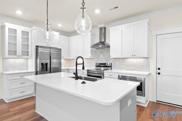 kitchen featuring wall chimney range hood, visible vents, stainless steel appliances, and dark wood-type flooring