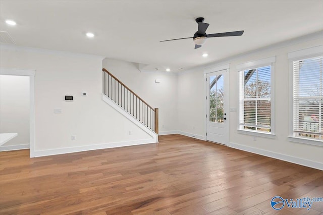 spare room featuring baseboards, stairway, ornamental molding, light wood-style floors, and recessed lighting