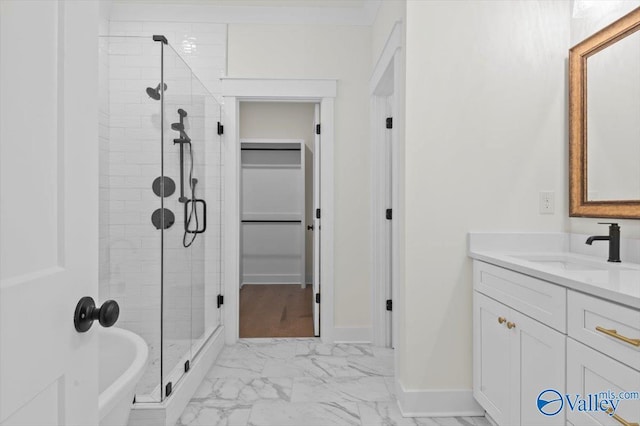 bathroom featuring a stall shower, marble finish floor, vanity, and baseboards