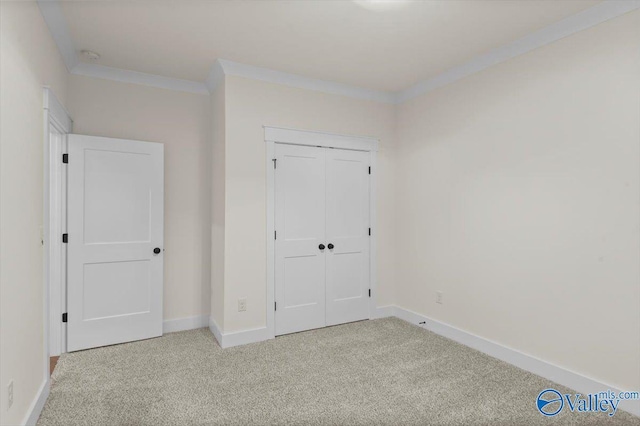 unfurnished bedroom featuring ornamental molding, carpet, a closet, and baseboards