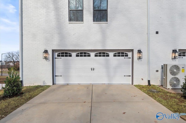 garage featuring ac unit and driveway