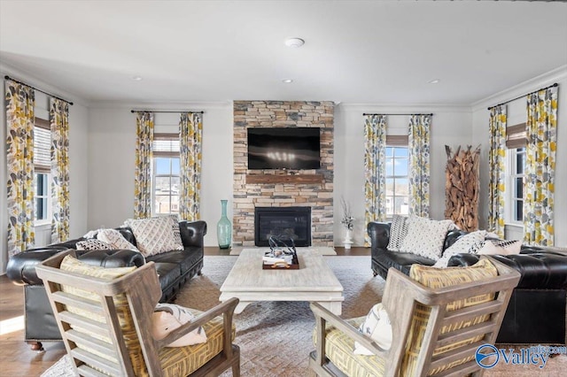 living room with a fireplace, crown molding, and wood finished floors