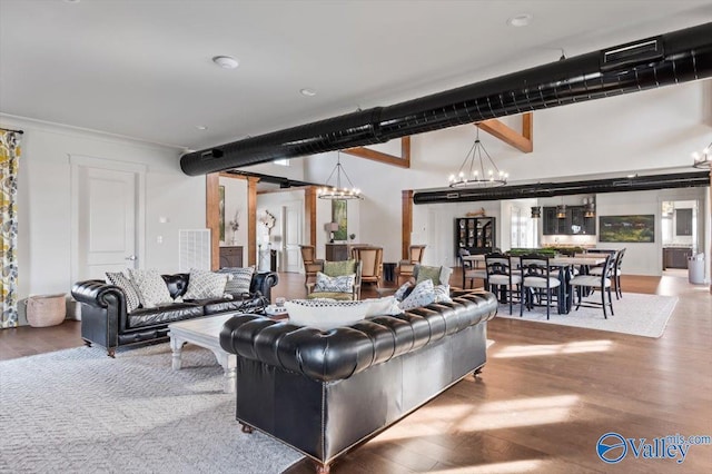 living area with visible vents, a notable chandelier, and wood finished floors