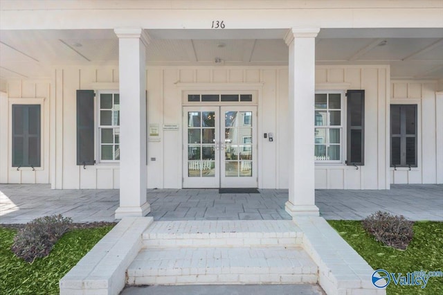 entrance to property featuring french doors, a porch, and board and batten siding