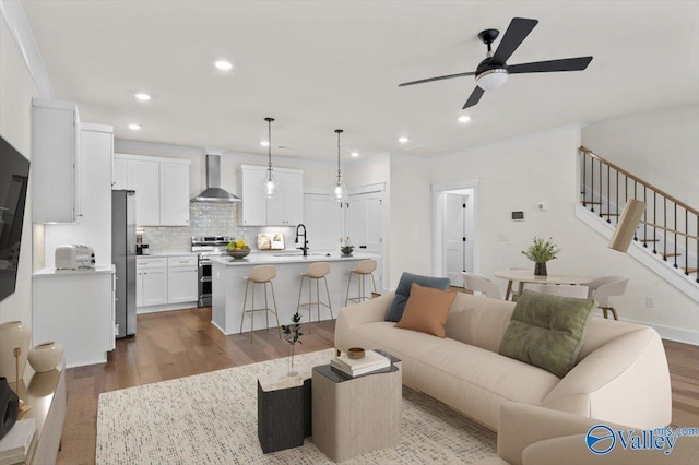 living room featuring dark wood-type flooring, recessed lighting, ceiling fan, and stairway