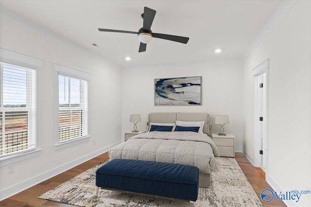 bedroom with ornamental molding, wood finished floors, visible vents, and baseboards