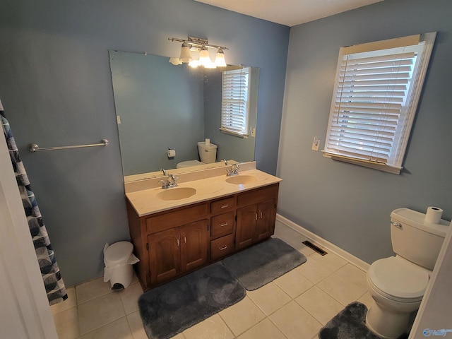 bathroom with toilet, vanity, and tile patterned floors