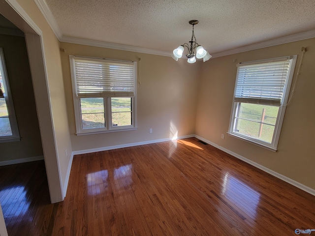 spare room with a chandelier, a textured ceiling, dark hardwood / wood-style floors, and plenty of natural light