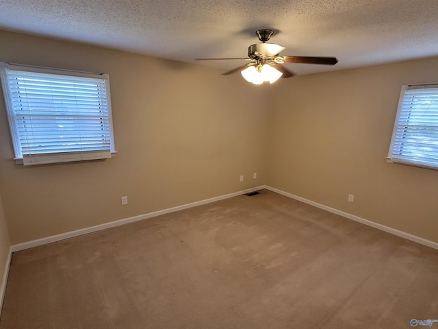 empty room featuring light carpet, ceiling fan, and a textured ceiling