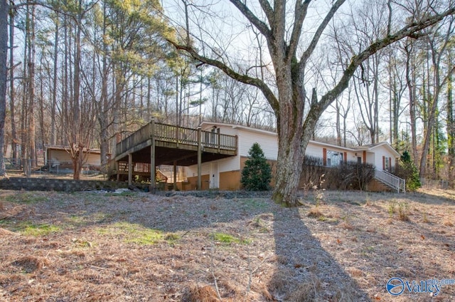 rear view of house featuring a wooden deck