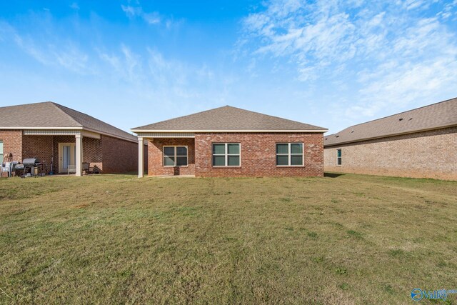 rear view of property featuring a yard