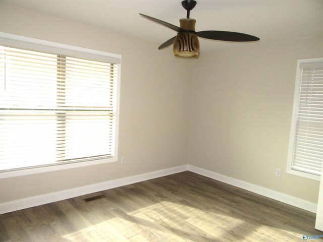 spare room with ceiling fan and dark hardwood / wood-style flooring