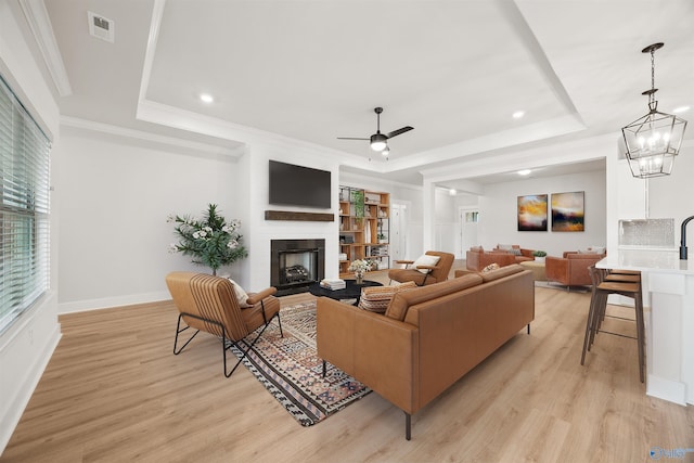 21837 Natures Cove Dr, Athens, AL 35613 - living area with a tray ceiling, light wood-style floors, ceiling fan, recessed lighting, and crown molding