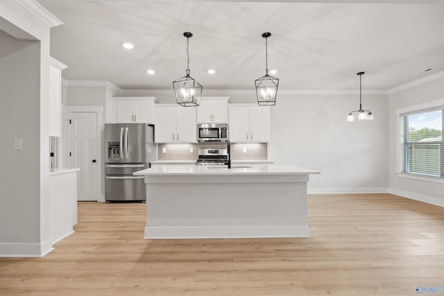 kitchen with appliances with stainless steel finishes, decorative light fixtures, crown molding, white cabinets, and light wood-type flooring