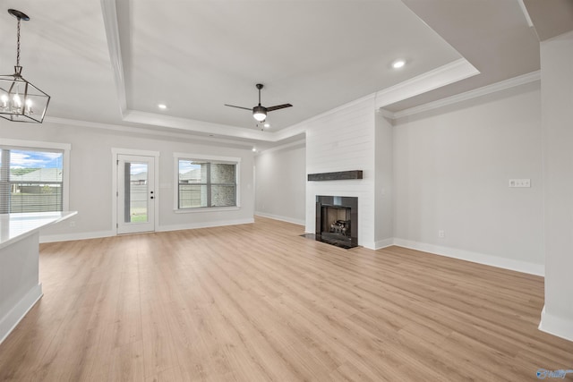 21837 Natures Cove Dr, Athens, AL 35613 - unfurnished living room with a tray ceiling, ornamental molding, light wood finished floors, a ceiling fan, and a chandelier