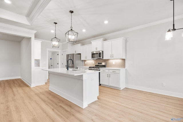 kitchen with a center island with sink, stainless steel appliances, light wood-type flooring, white cabinetry, and pendant lighting