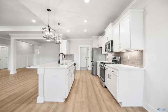 kitchen featuring pendant lighting, light hardwood / wood-style flooring, sink, white cabinetry, and appliances with stainless steel finishes