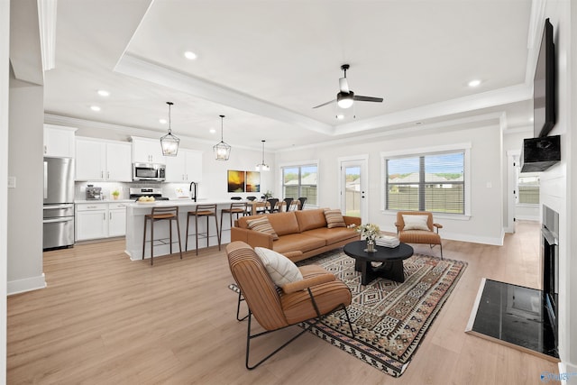 21837 Natures Cove Dr, Athens, AL 35613 - living area featuring a raised ceiling, a ceiling fan, recessed lighting, light wood finished floors, and ornamental molding
