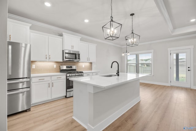 kitchen featuring white cabinetry, hanging light fixtures, an island with sink, and stainless steel appliances