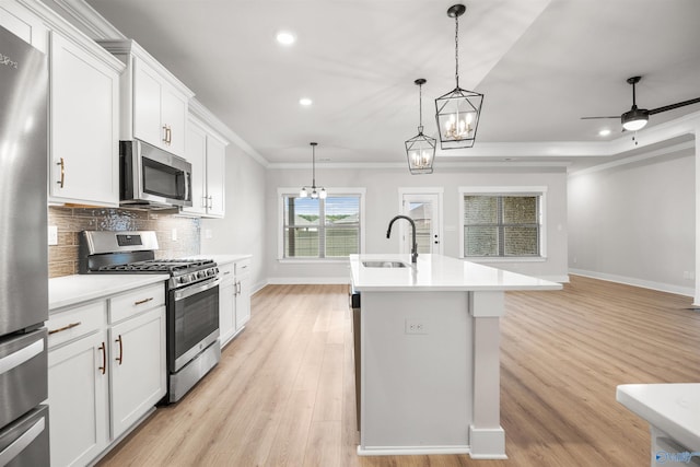 kitchen featuring white cabinetry, stainless steel appliances, sink, and an island with sink