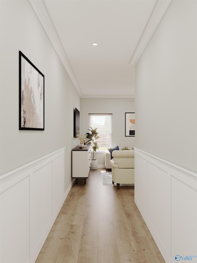 corridor with ornamental molding and light hardwood / wood-style flooring