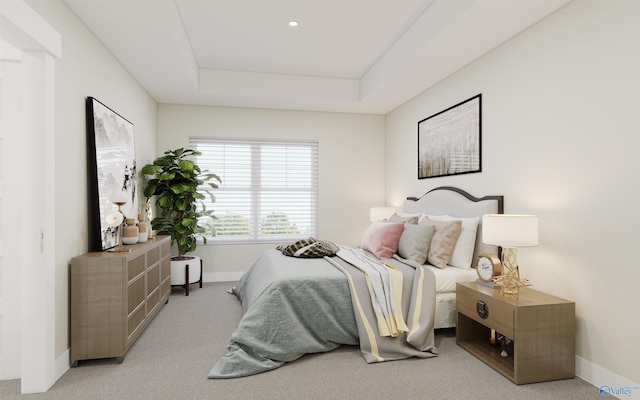 bedroom featuring light carpet and a tray ceiling