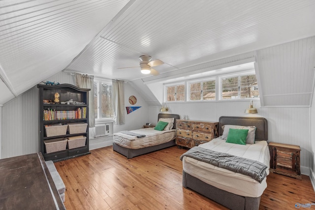 bedroom with cooling unit, hardwood / wood-style flooring, ceiling fan, and lofted ceiling