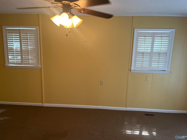 carpeted empty room featuring a textured ceiling and ceiling fan