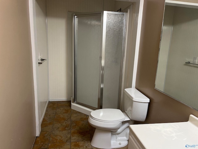 bathroom with vanity, toilet, and a shower with door