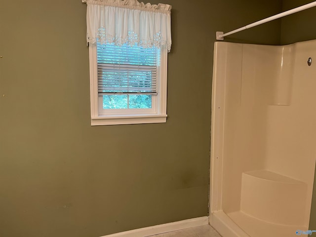 bathroom with tile patterned flooring and a shower