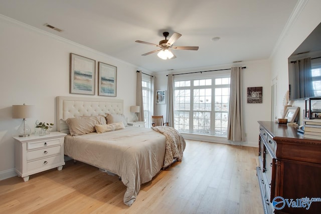 bedroom featuring ceiling fan, ornamental molding, multiple windows, and light wood-type flooring