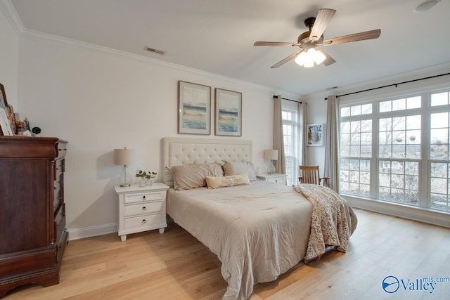 bedroom featuring ornamental molding, ceiling fan, and light wood-type flooring