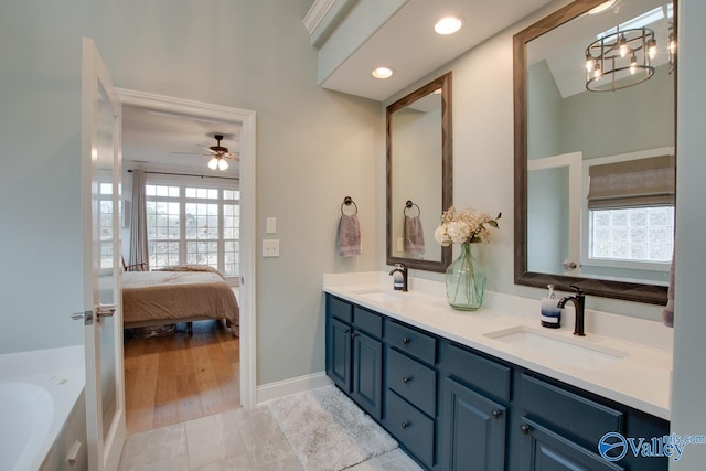 bathroom with vanity, ceiling fan, and a tub to relax in