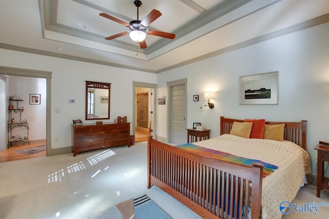 carpeted bedroom with ornamental molding, a raised ceiling, and ceiling fan