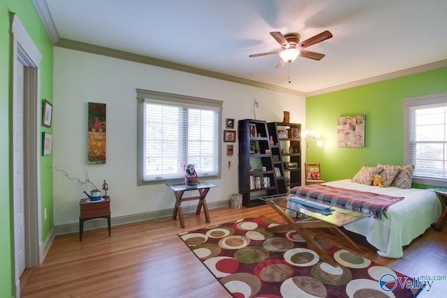 bedroom with hardwood / wood-style floors, ornamental molding, and ceiling fan