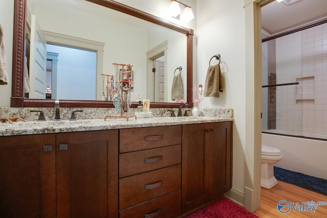 full bathroom with vanity, hardwood / wood-style floors, enclosed tub / shower combo, and toilet