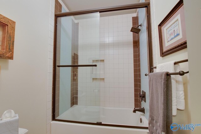 bathroom featuring combined bath / shower with glass door